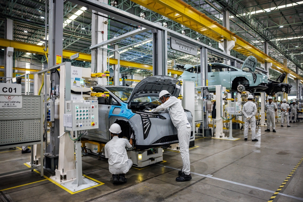 Factory employees inspect the chassis of a GAC Aion electric vehicle in Rayong, Thailand, on July 17, 2024. GAC Aion is the Electric vehicle arm of the Chinese state-owned Guangzhou Automobile Group.  (Lauren DeCicca/The New York Times)