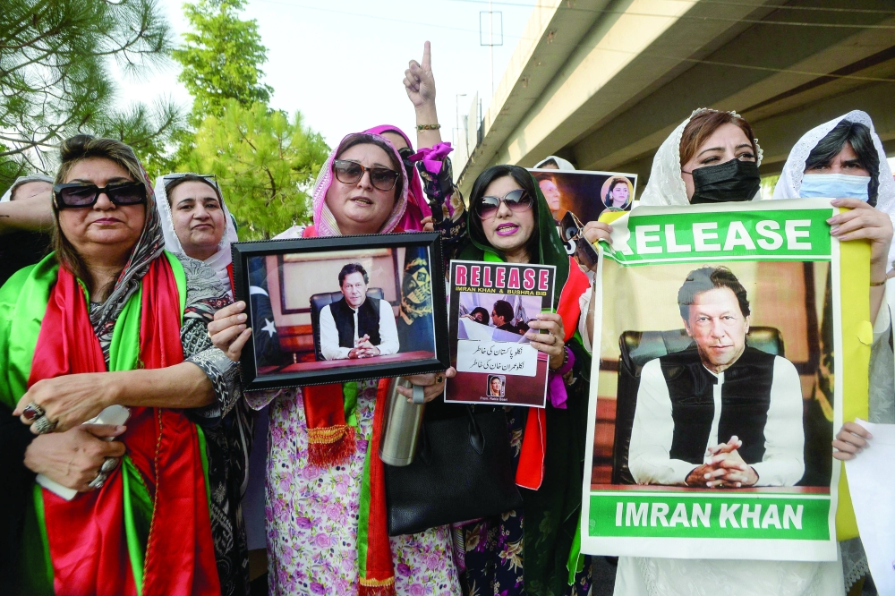 Activists and supporters of the Pakistan Tehreek-e-Insaf (PTI) party hold posters of jailed former prime minister Imran Khan as they take part in a demonstration demanding Khan's release in Peshawar on July 26, 2024.