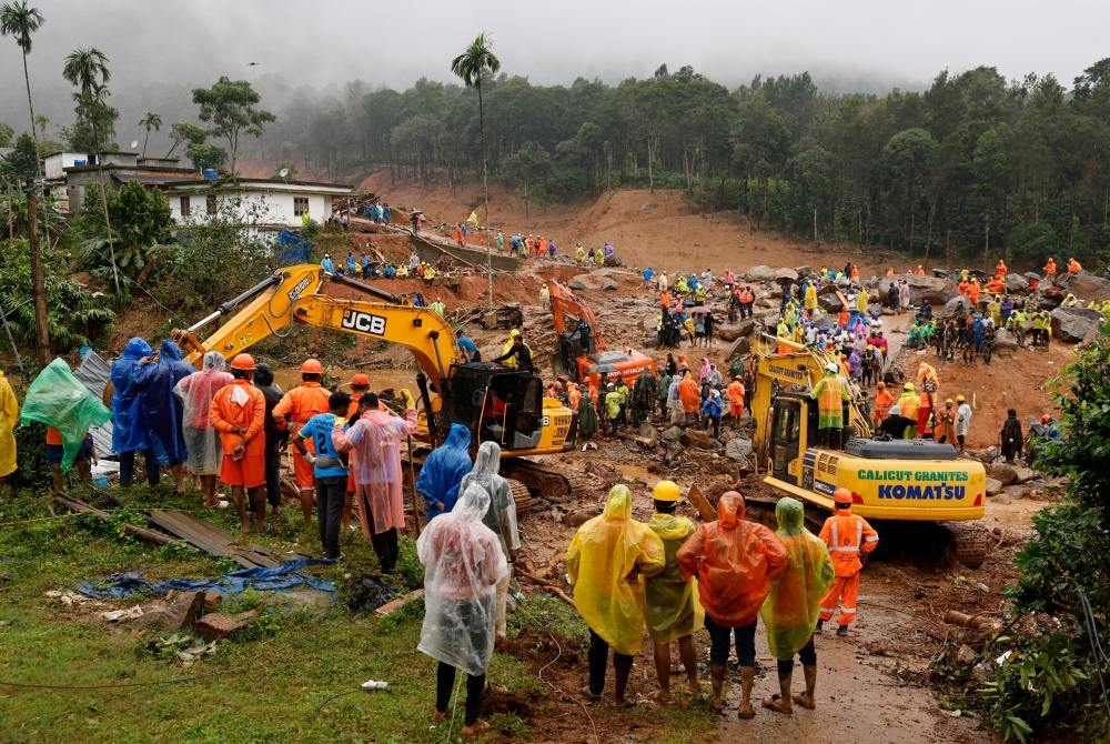 People watch as search operations are carried out after landslides hit Mundakkai village in Wayanad district in Kerala. - Reuters