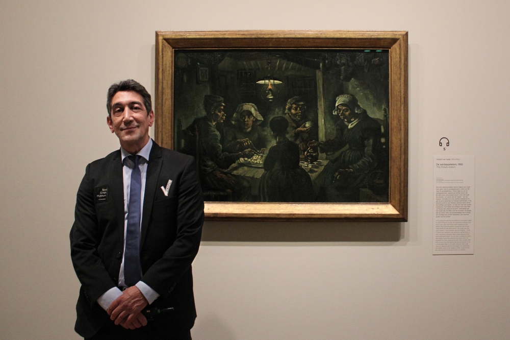 Mohammed Boukhrouf, a security guard at the Van Gogh Museum in Amsterdam, with Van Goghs The Potato Eaters, painted in Nuenen in 1885. (Nolle de Leeuw via The New York Times)