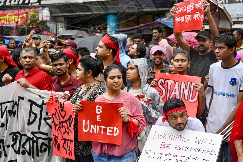 Protestors hold posters during a rally to demand justice for victims arrested and killed in the recent countrywide violence in Dhaka 