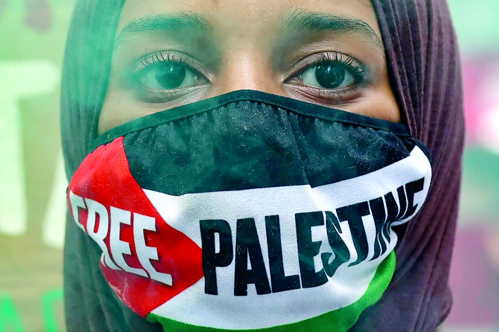 A protester marches in London during the 'National March for Gaza', calling to 'end the genocide, 'stop arming Israel' and 'no Middle East war' on Saturday. - AFP