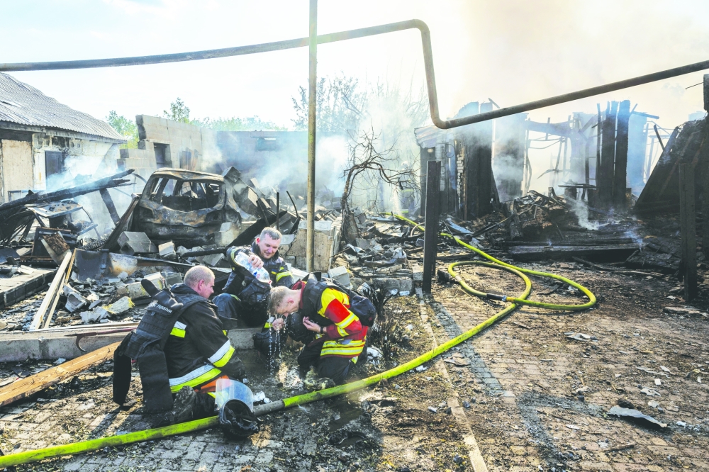 Ukrainian emergency workers cool off after extinguishing fires following a Russian strike on a residential area in Pokrovsk. — Reuters 