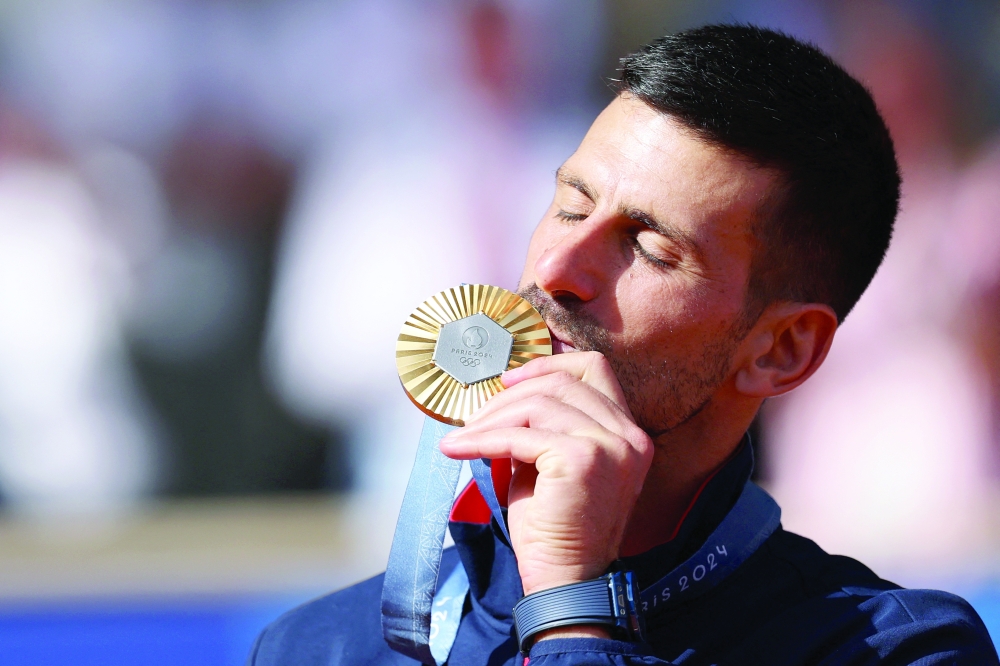 Novak Djokovic of Serbia kisses his medal. — REUTERS