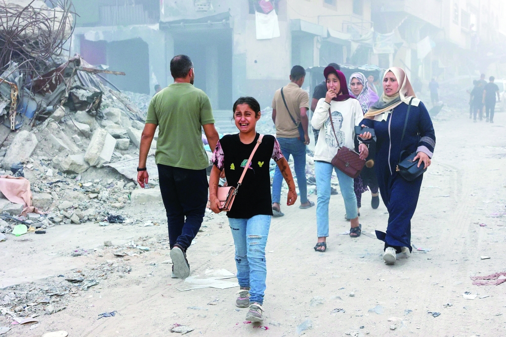 A Palestinian girl cries following Israeli bombardment which hit a school complex, including the Hamama and Al Huda schools, in the Sheikh Radwan neighbourhood in the north of Gaza City on Sunday. — AFP