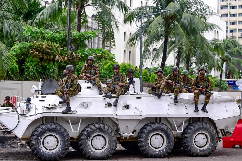 Bangladesh army personnel stand guard during a curfew