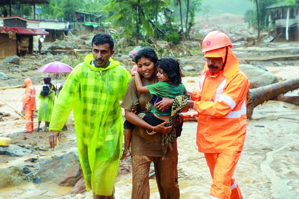 Rescuers help residents to move to a safer place, at a landslide site after multiple landslides in the hills, in Wayanad. - Reuters file photo