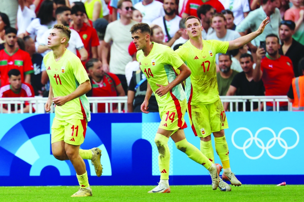Fermin Lopez (L) celebrates with Aimar (C) and Sergio. — AFP