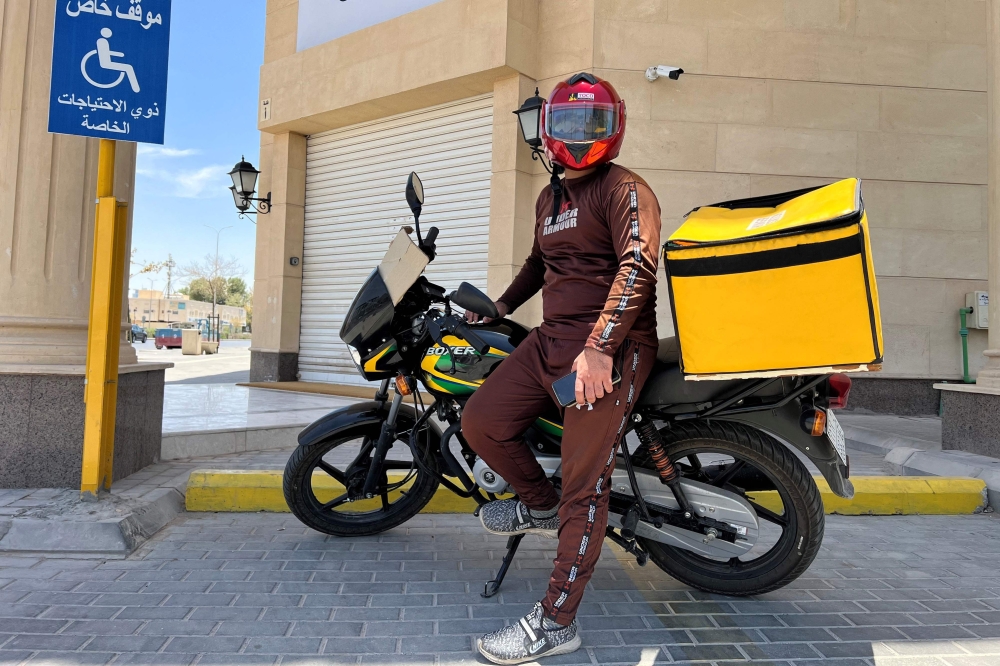 A delivery worker poses for a photo during a break to cool down in central Riyadh 