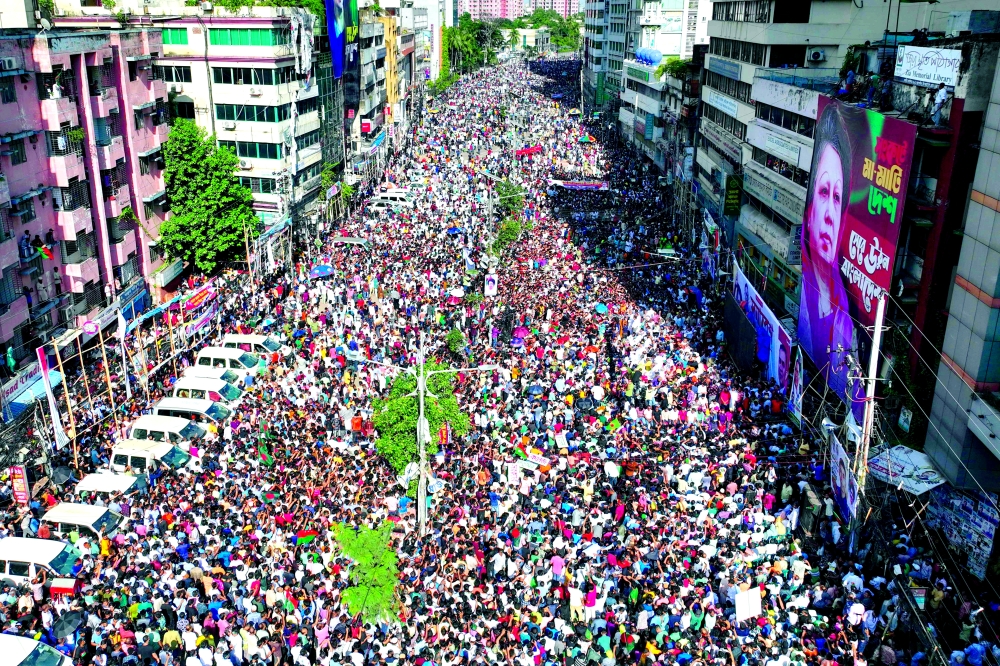 Bangladesh Nationalist Party (BNP) activists gather near a poster of BNP chairperson Khaleda Zia, during a rally in Dhaka. — AFP