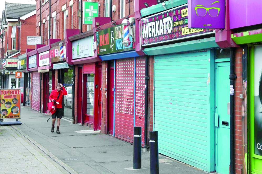 A man walks past closed businesses in the midst of unrest due to rioting across the country, in Manchester. — Reuters 