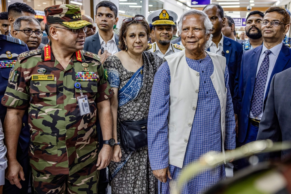 Senior members of the Bangladesh Army receive Nobel laureate Muhammad Yunus upon his arrival at the Hazrat Shahjalal International Airport in Dhaka. - AFP
