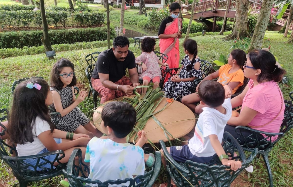 Children learning to make craft from palm leaves at the resort
