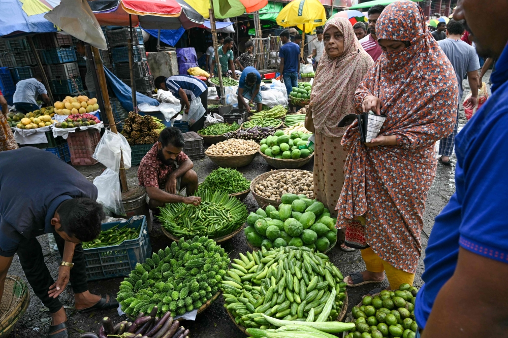 A man carries a basket of vegetables at a market in Dhaka 