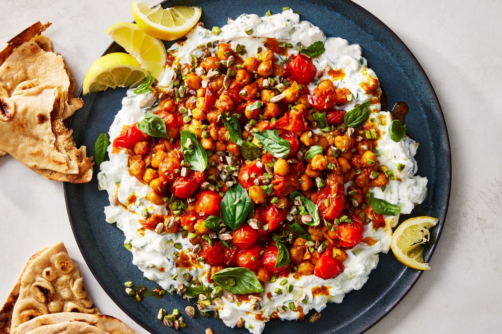 Curry tomatoes and chickpeas with cucumber yogurt. Food styled by Barrett Washburne. (Rachel Vanni/The New York Times)