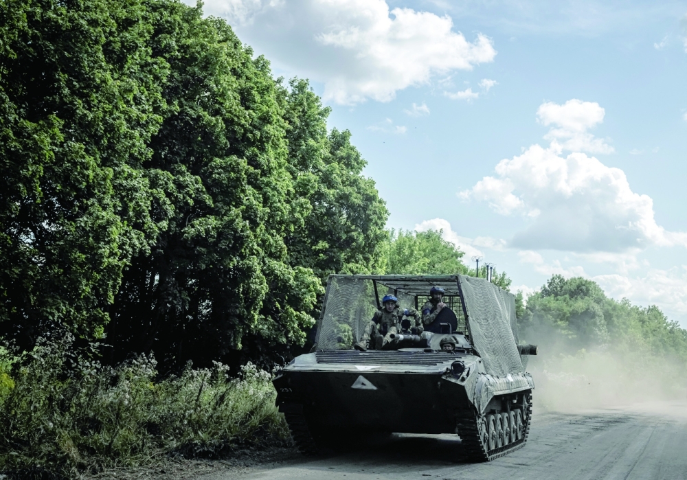 Ukrainian service members ride a fighting vehicle, near the Russian border in Sumy region, Ukraine. — Reuters 