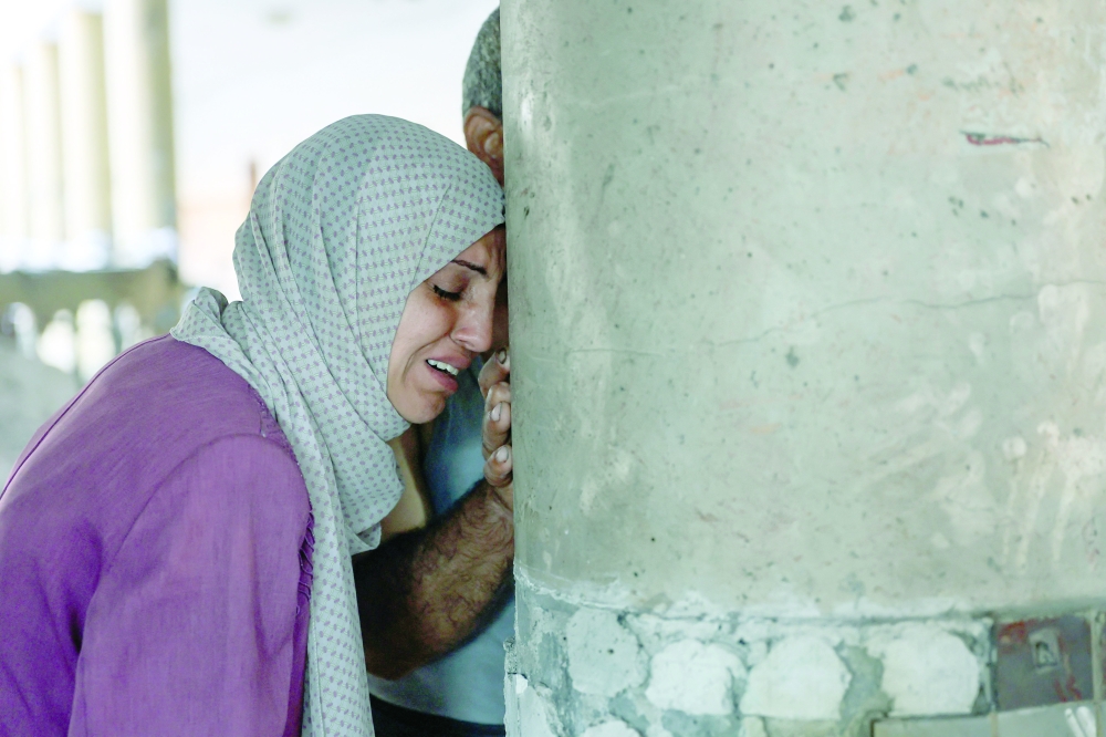 A woman cries inside a school used as a temporary shelter for displaced Palestinians in Gaza City, after it was hit by an Israeli strike on Saturday. - AFP