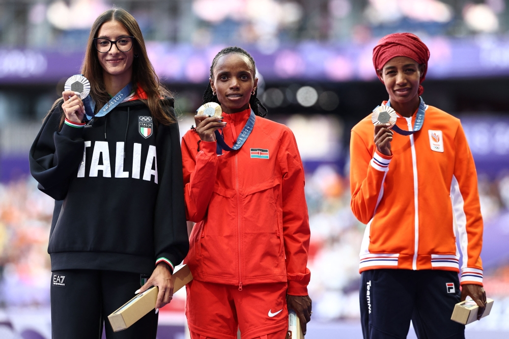 (L-R) Silver medallist Italy's Nadia Battocletti, gold medallist Kenya's Beatrice Chebet and bronze medallist Netherlands' Sifan Hassan celebrate on the podium. — AFP