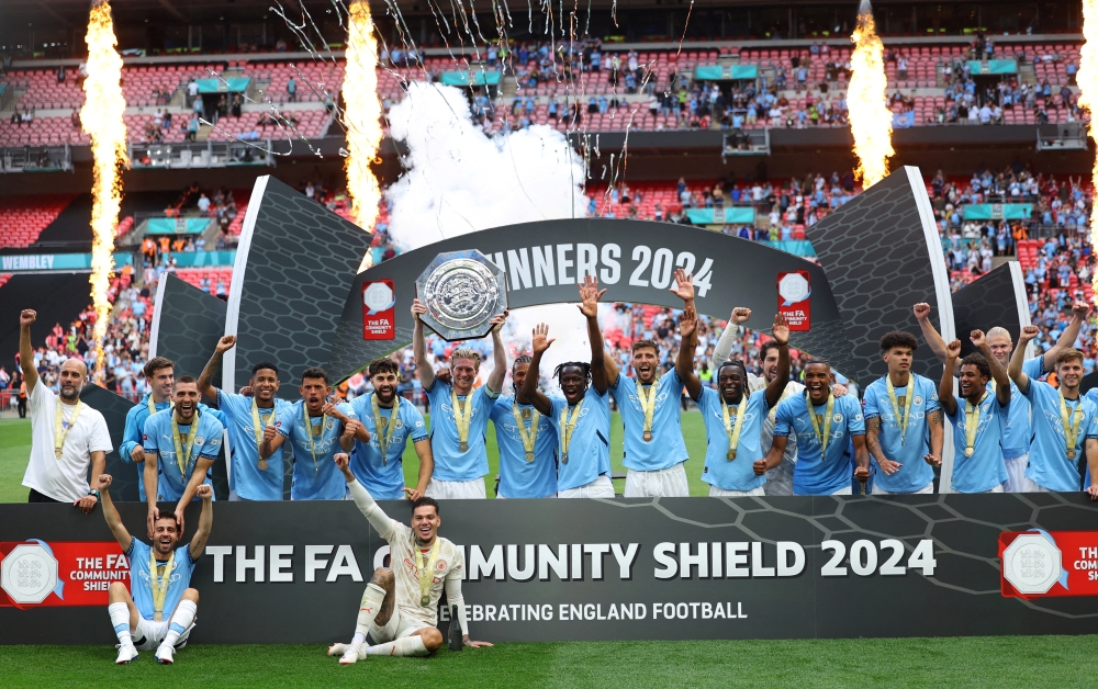 Manchester City's Kevin De Bruyne lifts the trophy with teammates. —Reuters
