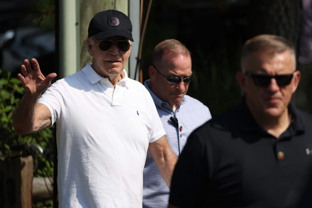 US President Joe Biden (L) waves as he departs the beach, in Rehoboth Beach, Delaware. — AFP 