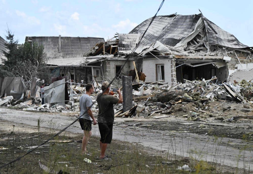 Residents look at a residential house, heavily damaged following a Russian missile strike, in a village in the Brovary district, Kyiv . — AFP 
