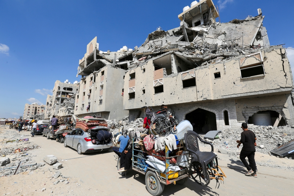 Displaced Palestinians make their way as they flee Hamad City following an Israeli evacuation order, in Khan Younis. — Reuters 