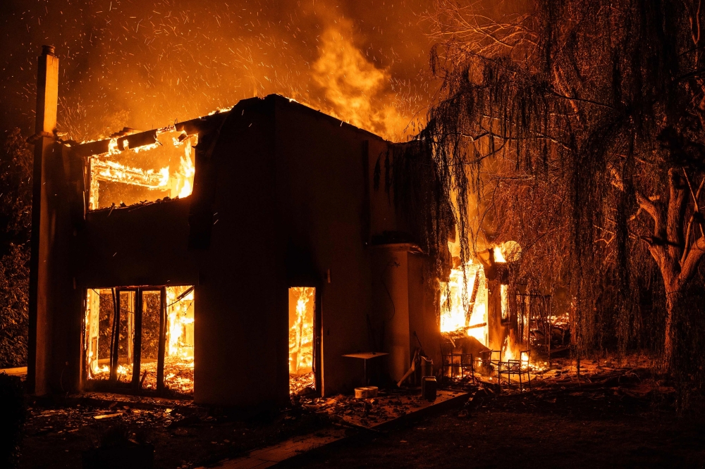 A house burns during a wildfire in Varnavas, north of Athens
