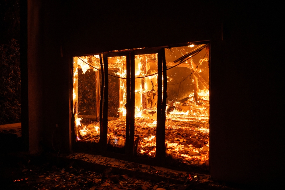 A house burns during a wildfire in Varnavas, north of Athens