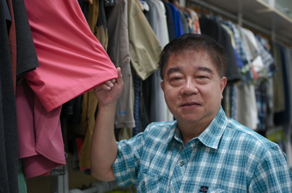 This picture taken on July 5, 2024 shows Eddie Wang, chairman of the Creative Tech Textile company which repurposes discarded oyster shells into Seawool, a trademarked and patented fabric, posing for photographs at the factory in Tainan. Growing up on Taiwan's west coast where mollusc farming is popular, Eddie Wang saw discarded oyster shells transformed from waste to function -- a memory that inspired him to create a unique and environmentally friendly fabric called "Seawool".  
 - To go with: TAIWAN-ENVIRONMENT-AGRICULTURE-BUSINESS-RECYCLE-TEXTILE, FEATURE by Amber WANG
 (Photo by Sam Yeh / AFP) / To go with: TAIWAN-ENVIRONMENT-AGRICULTURE-BUSINESS-RECYCLE-TEXTILE, FEATURE by Amber WANG

