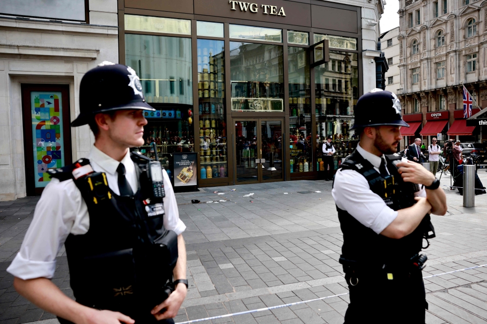 Police officers stand by a cordoned off area in Leicester square, London. — AFP