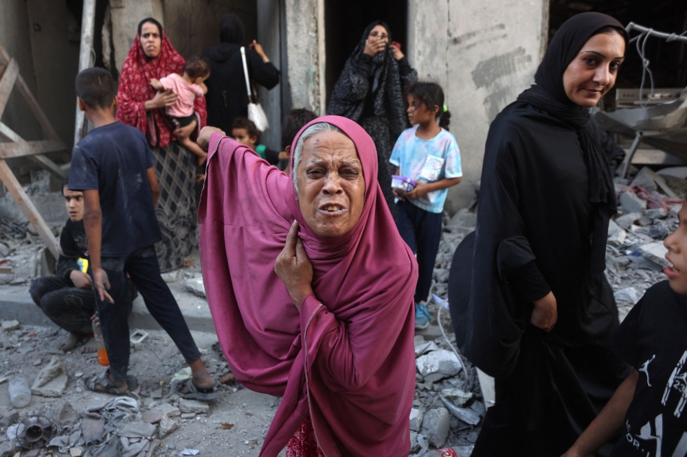 A woman reacts as people inspect the damage following Israeli bombardment in Gaza City's Sheikh Radwan neighbourhood on Monday. - AFP