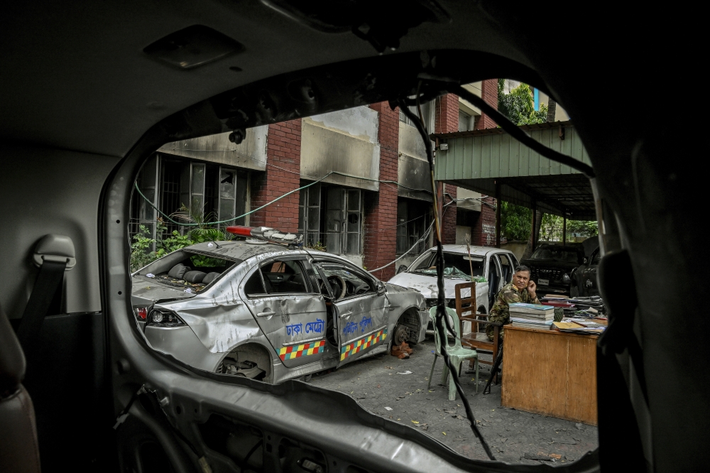 Damaged police cars sit in front of an abandoned police station in Dhaka, Bangladesh, on Aug. 11, 2024. (Atul Loke/The New York Times)