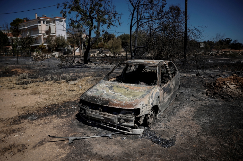 FILE PHOTO: A view of a burned-out car, following the wildfire in the Halandri suburb in Athens, Greece, August 13, 2024. REUTERS/Louisa Gouliamaki/File Photo