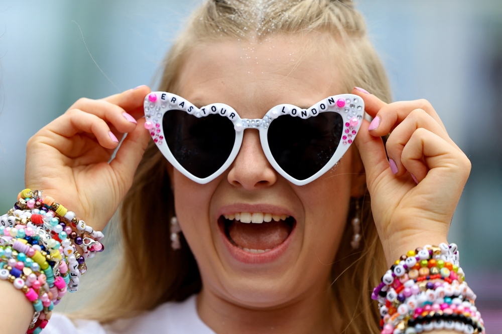 A fan wearing Taylor Swift sunglasses reacts ahead of her concert, following the cancellation of three Taylor Swift concerts in Vienna because of a planned attack, at Wembley Stadium in London, Britain, August 15, 2024.  REUTERS/Toby Melville
