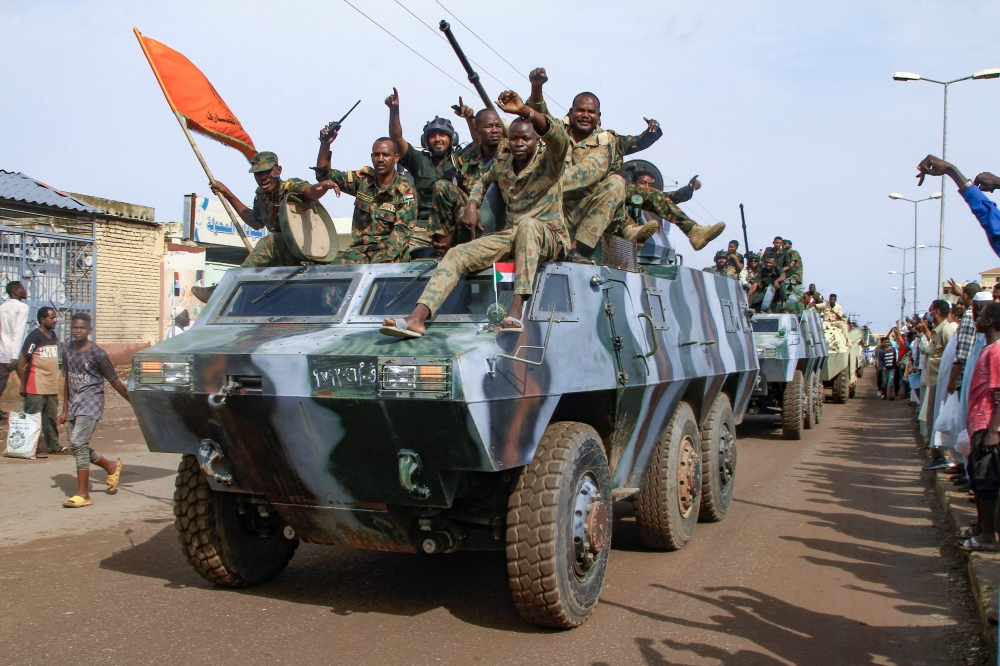 People cheer members of Sudan's armed forces taking part in a military parade held on Army Day in Gadaref. - AFP

