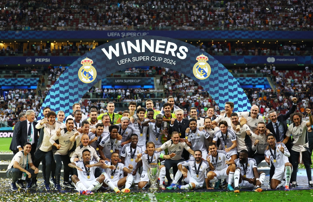   Real Madrid players celebrate with the trophy after winning the Super Cup REUTERS 
