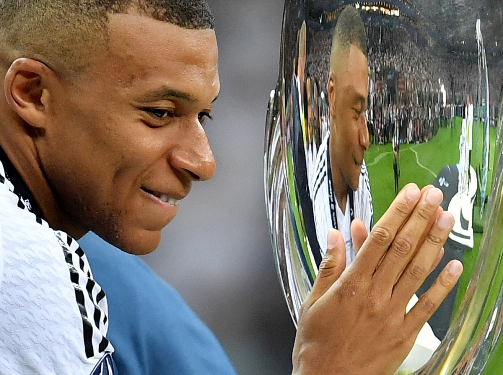   Real Madrid's Kylian Mbappe touches the trophy after winning the Super Cup REUTERS 
