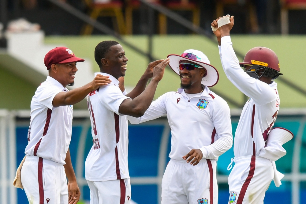 Shamar Joseph (2L), Gudakesh Motie (L) and Kavem Hodge (3L) of West Indies celebrate the dismissal of David Bedingham of South Africa 