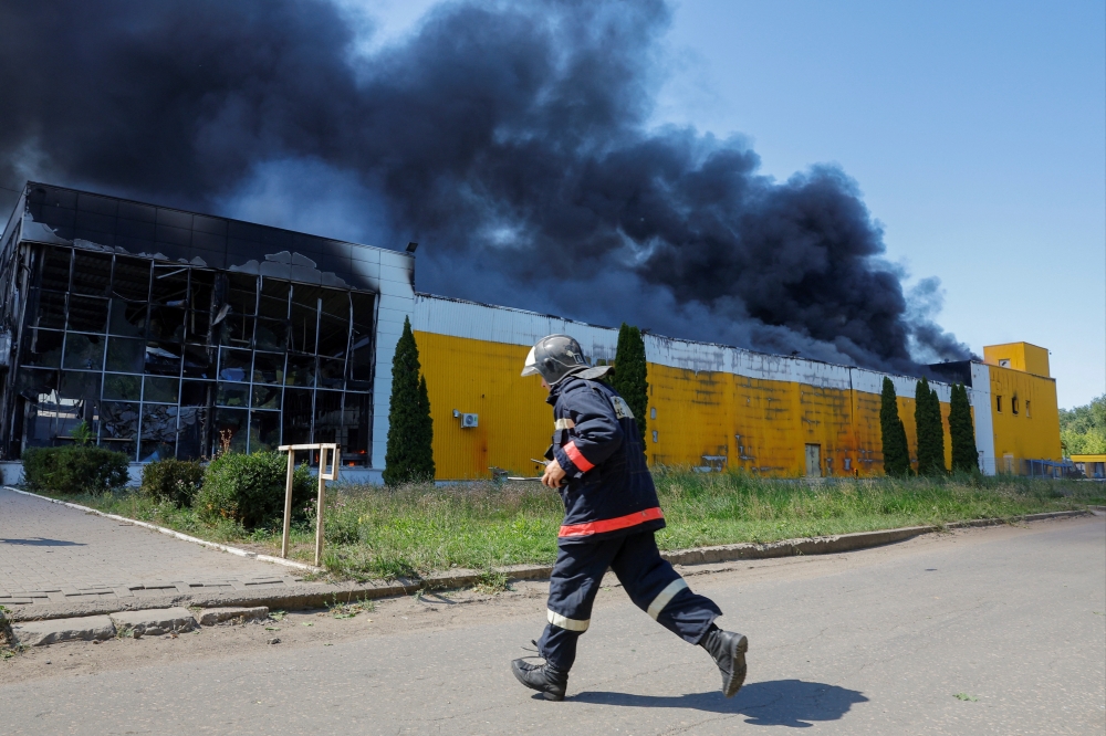 Smoke rises above the burning shopping mall Galaktika hit by shelling, in Donetsk