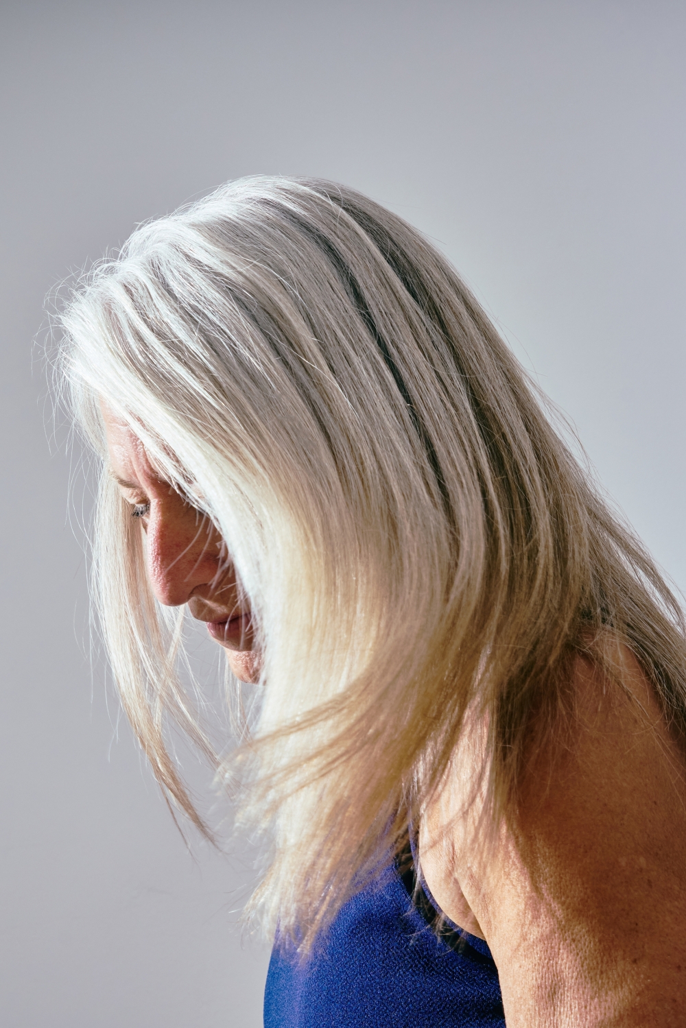 A women with gray hair in Los Angeles in June 2024. Some studies have linked the stress hormone norepinephrine to premature graying. (Joyce Lee/The New York Times)