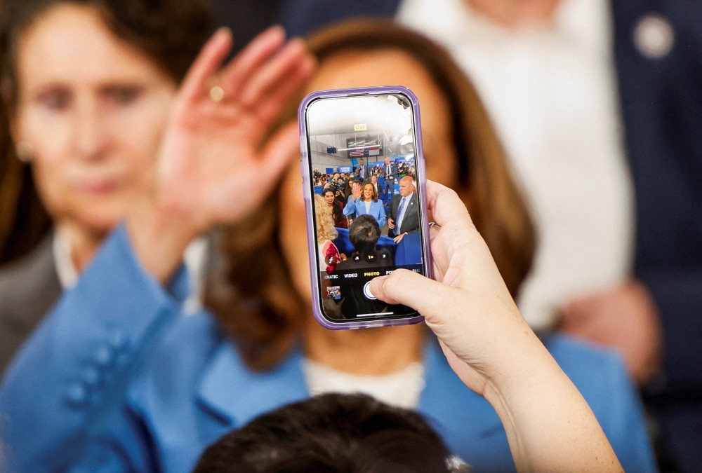 A person takes a picture of U.S. Vice President and Democratic presidential candidate Kamala Harris