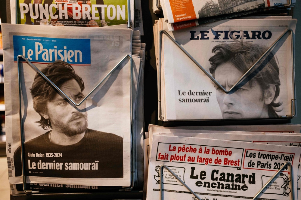 This photograph shows the front pages of French newspapers showing the news of the death of French actor Alain Delon