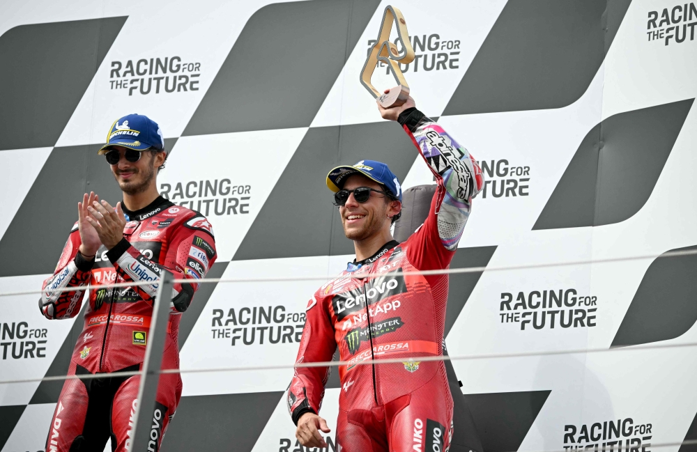 Bagnaia (L) and third placed Bastianini celebrate on the podium after the Austrian MotoGP race a