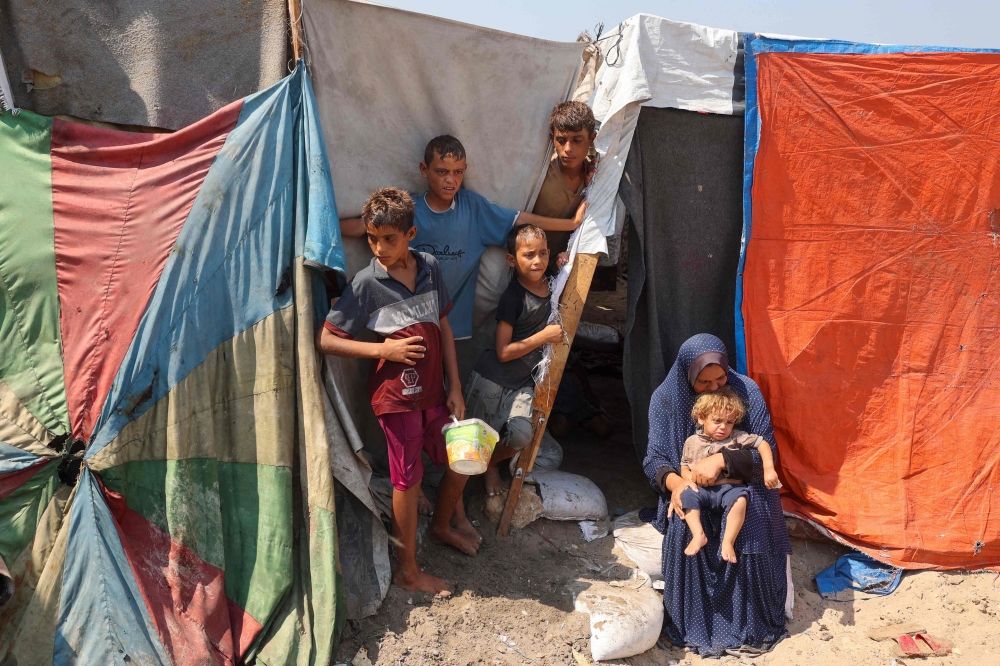 People look on outside their tent at a makeshift camp for displaced Palestinians  