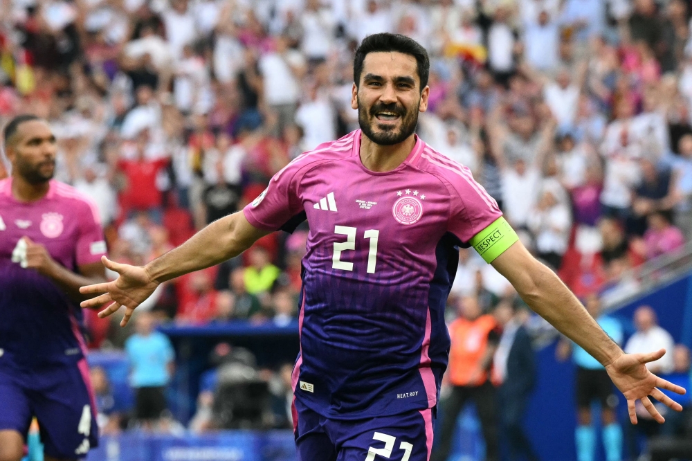 (FILES) Germany's midfielder #21 Ilkay Gundogan celebrates scoring his team's second goal during the UEFA Euro 2024 Group A football match between Germany and Hungary at the Stuttgart Arena in Stuttgart on June 19, 2024. Germany captain Ilkay Gundogan announced his retirement from international football on August 19, 2024 after leading his country at Euro 2024, citing "a certain tiredness" both physically and mentally. (Photo by THOMAS KIENZLE / AFP)

