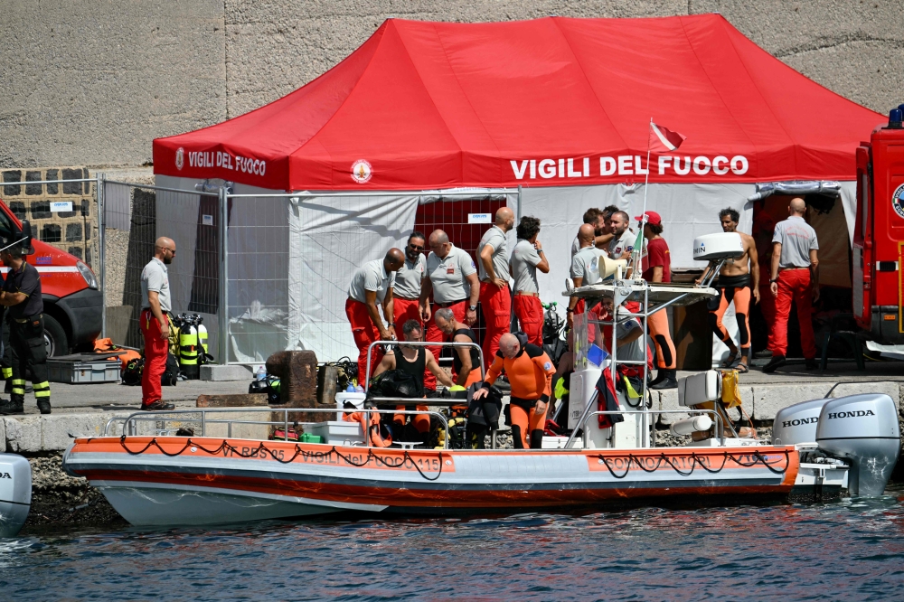 Divers of the Vigili del Fuoco, the Italian Corps. of Firefighters, return to Porticello on a small boat. — AFP 