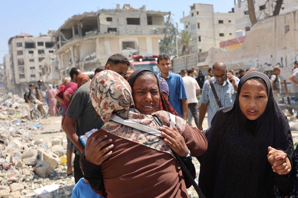 Palestinians react after an Israeli strike on a school, housing displaced Palestinians, in the Rimal neighbourhood. — AFP 