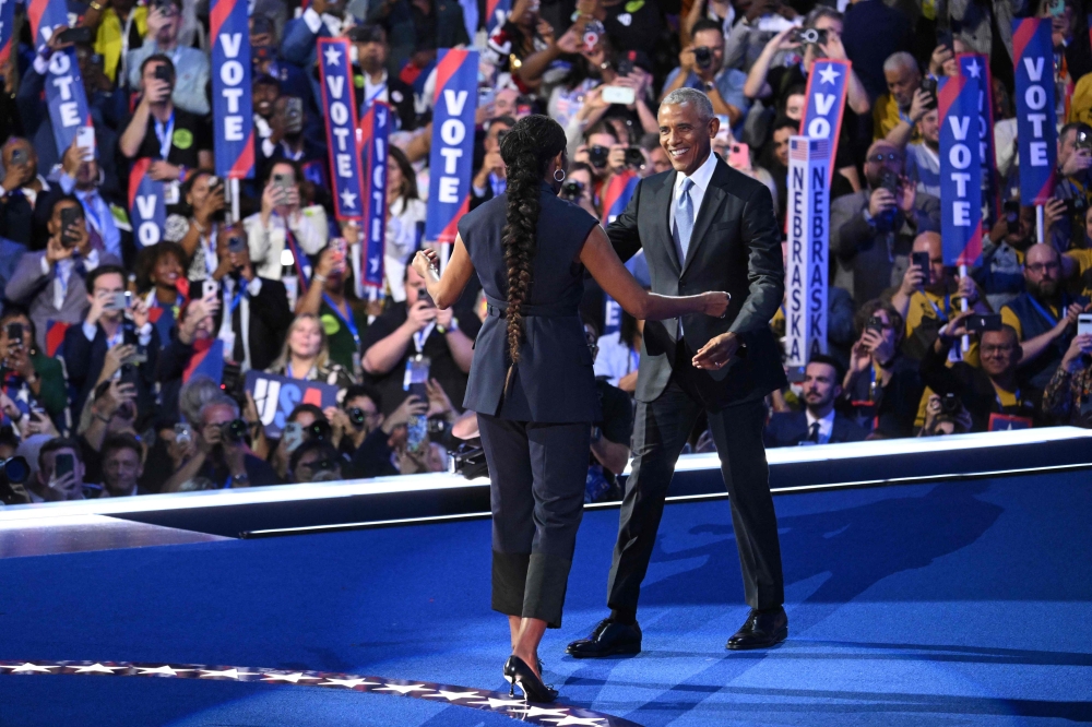 Former US President Barack Obama (R) approaches wife former US First Lady Michelle Obama 