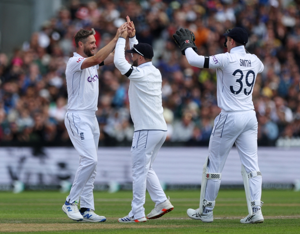 Cricket - First Test - England v Sri Lanka - Old Trafford, Manchester, Britain - August 21, 2024 England's Chris Woakes celebrates with teammates after taking the lbw wicket of Sri Lanka's Angelo Mathews Action Images via Reuters/Lee Smith
