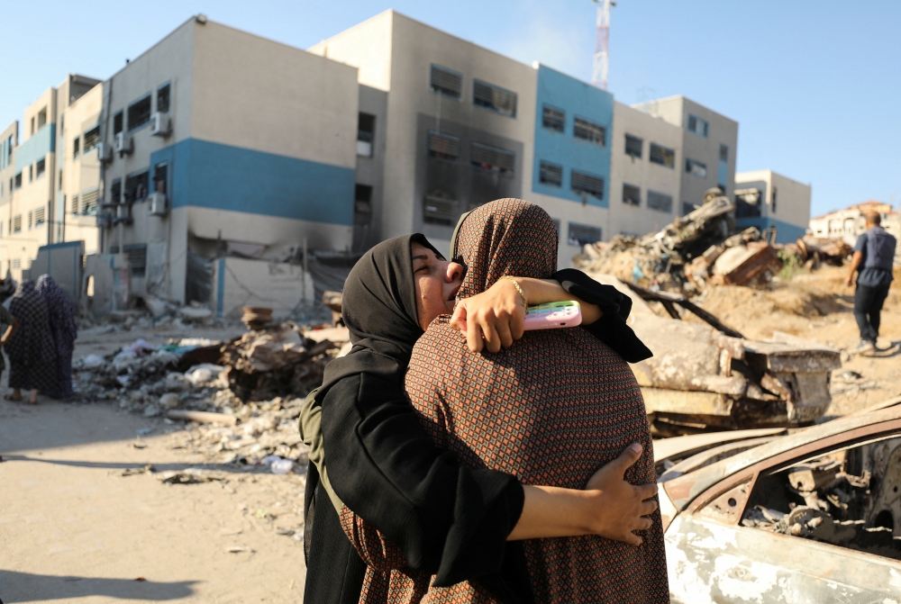 Palestinians react, after a school sheltering displaced people was hit by an Israeli strike, in Gaza City, on Wednesday. - Reuters